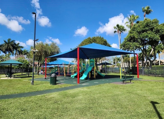 community play area featuring fence and a lawn