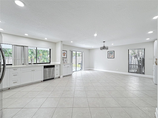 interior space with a sink, stainless steel dishwasher, light countertops, and recessed lighting