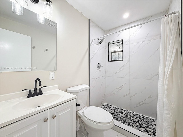 bathroom featuring vanity, toilet, and a shower stall