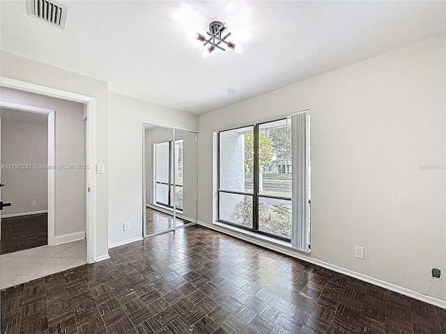 unfurnished bedroom with baseboards, a closet, and visible vents
