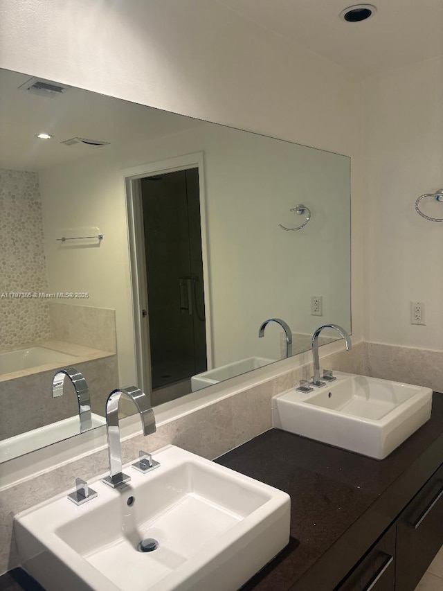 full bath with a sink, a stall shower, and recessed lighting