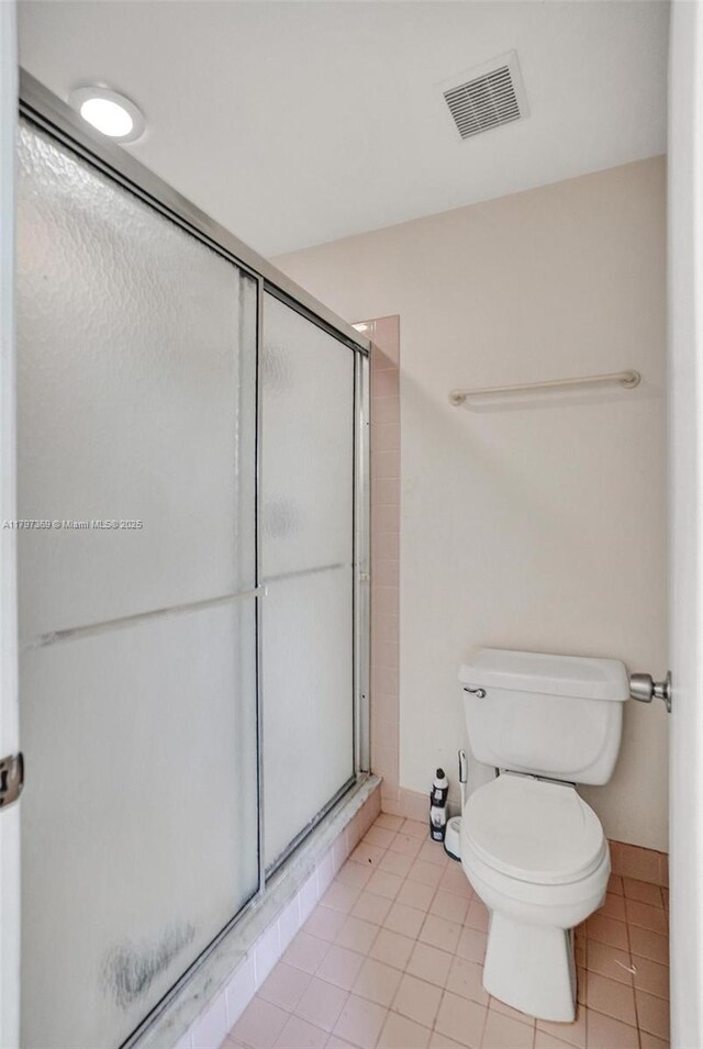 full bathroom with toilet, baseboards, visible vents, a shower stall, and tile patterned flooring