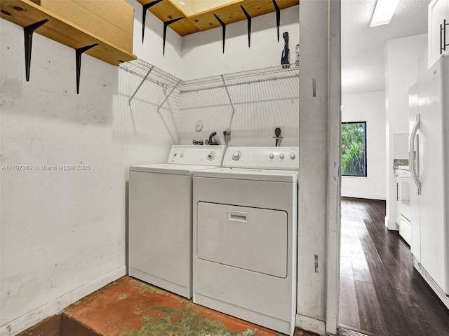 laundry area featuring washer and clothes dryer, baseboards, and dark wood-type flooring