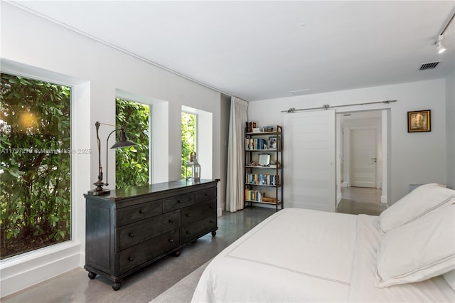 bedroom featuring a barn door and visible vents