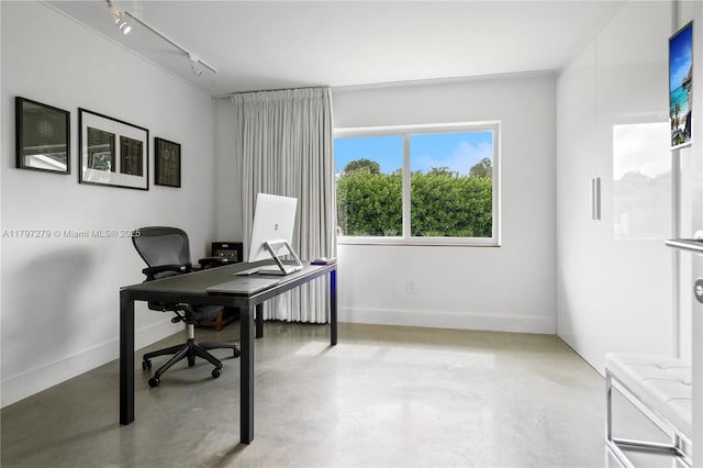 office with rail lighting, concrete flooring, and baseboards