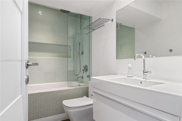 bathroom with toilet, tiled shower / bath combo, and vanity