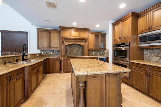 kitchen with stainless steel appliances, tasteful backsplash, a sink, and a kitchen island