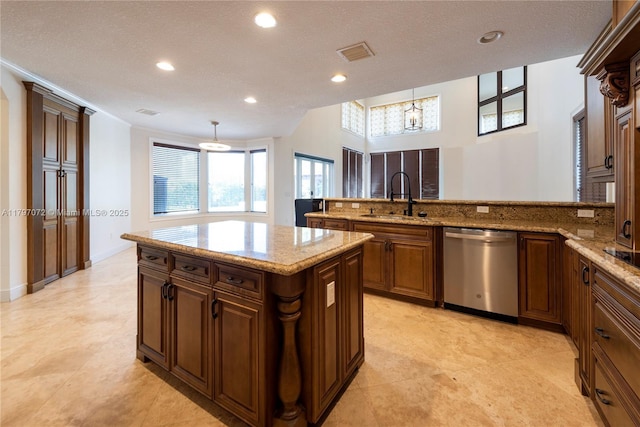 kitchen featuring a sink, stainless steel dishwasher, decorative light fixtures, and visible vents