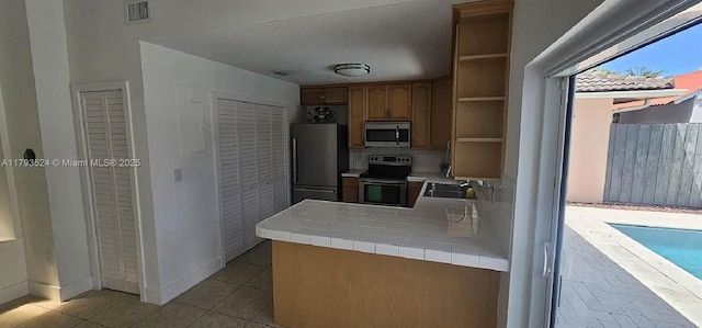 14661 SW 50th St, Miami, FL 33175 - kitchen with light tile patterned floors, open shelves, stainless steel appliances, tile counters, and visible vents