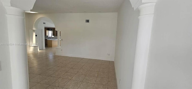 14661 SW 50th St, Miami, FL 33175 - empty room featuring light tile patterned floors, baseboards, visible vents, decorative columns, and arched walkways