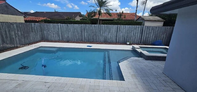 14661 SW 50th St, Miami, FL 33175 - view of swimming pool featuring a pool with connected hot tub and a fenced backyard