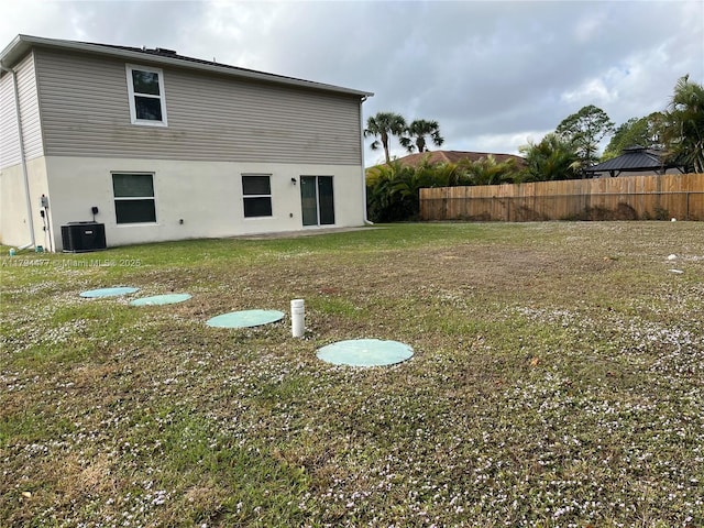 741 White Cloud St SW, Palm Bay, FL 32908 - rear view of house with central air condition unit, a yard, stucco siding, and fence