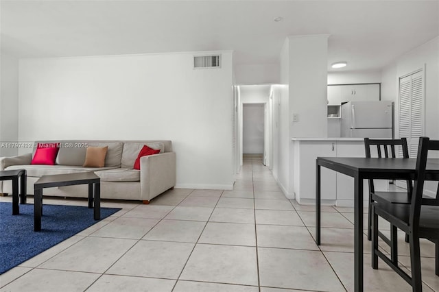 living room with light tile patterned flooring, baseboards, and visible vents