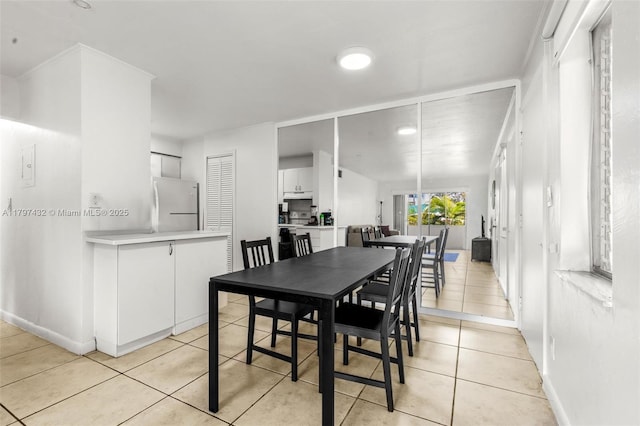 dining room featuring light tile patterned flooring and baseboards