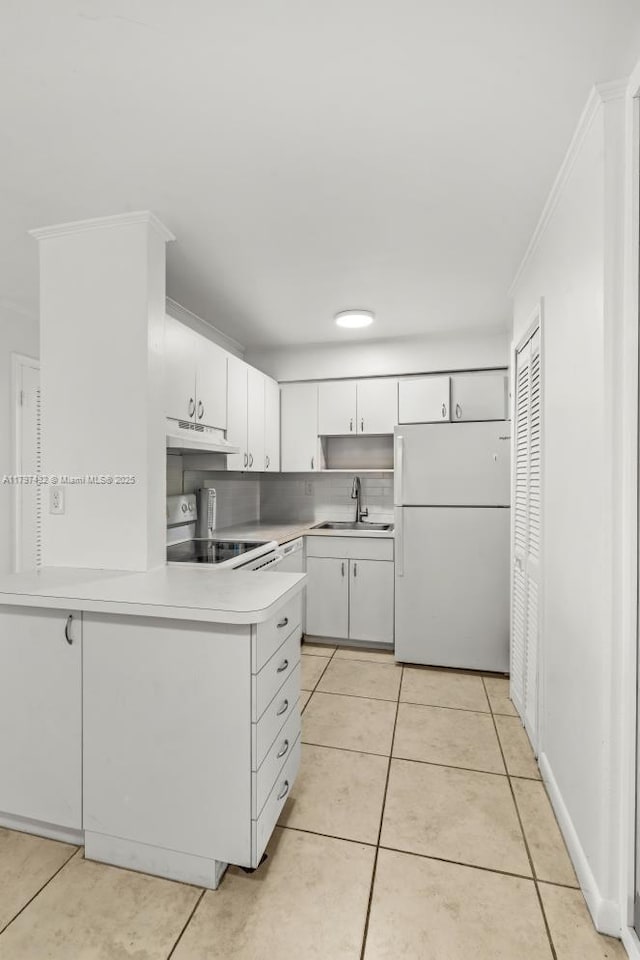 kitchen featuring freestanding refrigerator, light tile patterned floors, under cabinet range hood, and electric stove