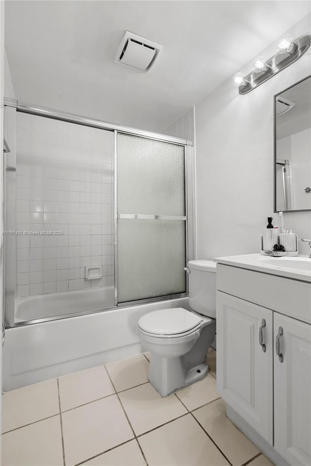 bathroom featuring toilet, visible vents, tile patterned flooring, bath / shower combo with glass door, and vanity