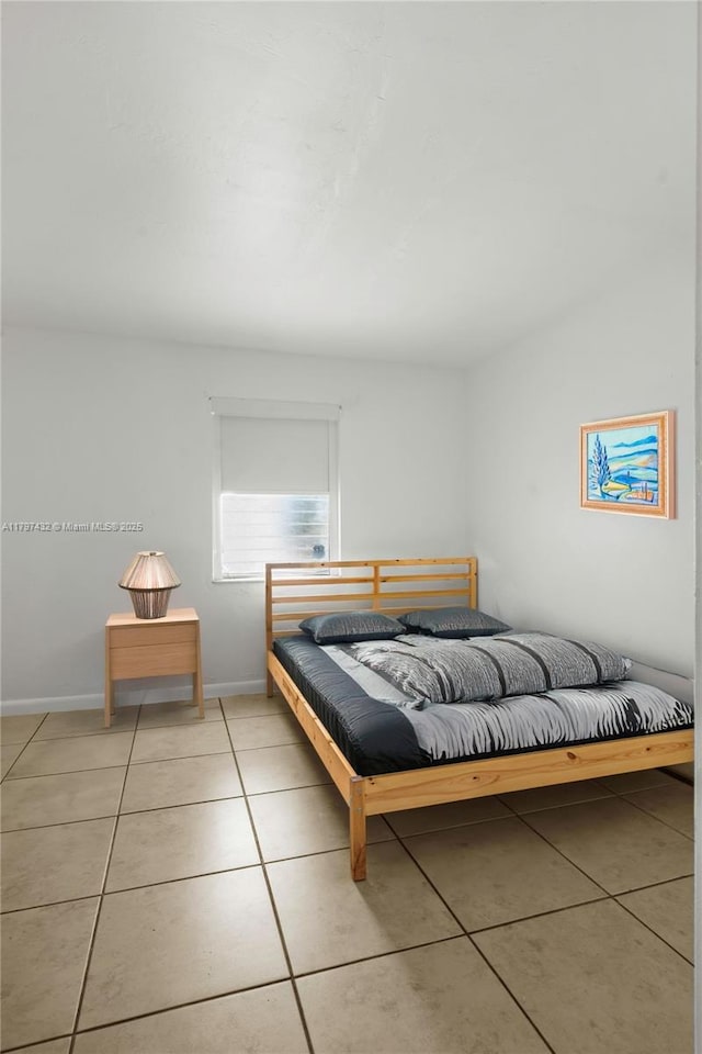 bedroom featuring light tile patterned floors and baseboards
