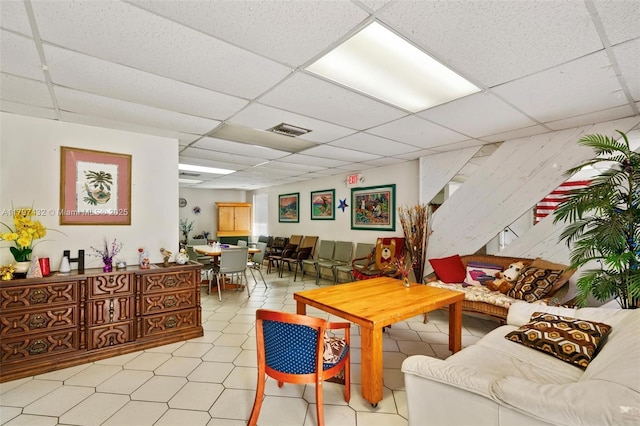 living room with visible vents, light tile patterned floors, and a drop ceiling