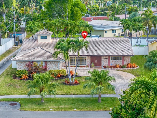 1243 Funston St, Hollywood, FL 33019 - view of front of property with a tiled roof, driveway, fence, and a front yard