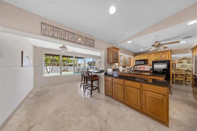 1243 Funston St, Hollywood, FL 33019 - kitchen featuring visible vents, ceiling fan, a peninsula, vaulted ceiling, and black appliances