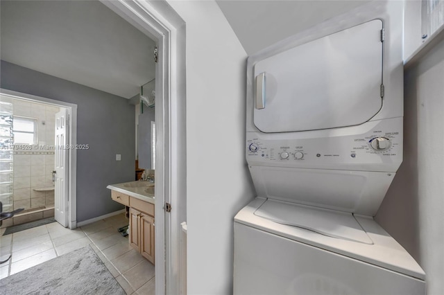1243 Funston St, Hollywood, FL 33019 - laundry area with laundry area, stacked washing maching and dryer, baseboards, and light tile patterned floors