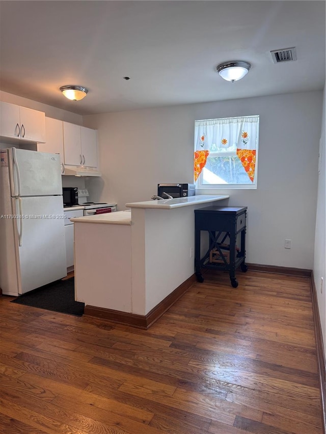 361 Collins Ave Unit A2, Miami Beach, FL 33139 - kitchen with white appliances, dark wood-style flooring, white cabinets, baseboards, and a peninsula