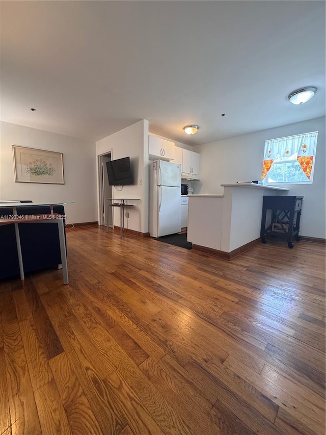 361 Collins Ave Unit A2, Miami Beach, FL 33139 - kitchen with freestanding refrigerator, baseboards, white cabinetry, a peninsula, and dark wood-style floors