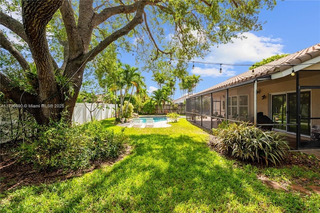 view of yard with a fenced backyard, a sunroom, and a fenced in pool