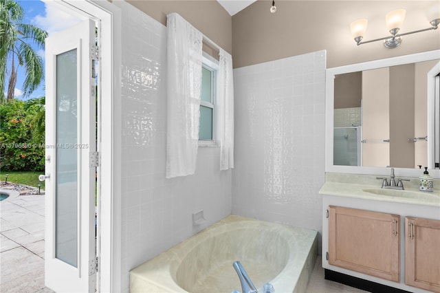 bathroom featuring a garden tub, a shower, and vanity
