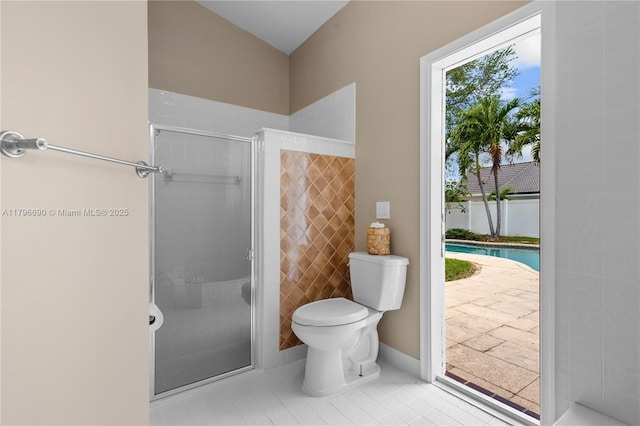 bathroom featuring a stall shower, tile patterned floors, and toilet