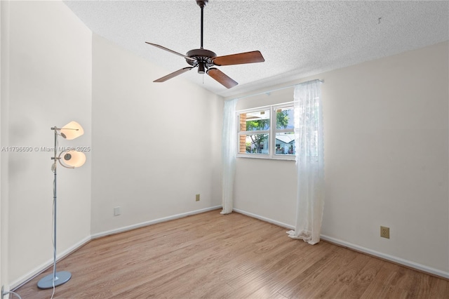 unfurnished room with baseboards, ceiling fan, a textured ceiling, and wood finished floors