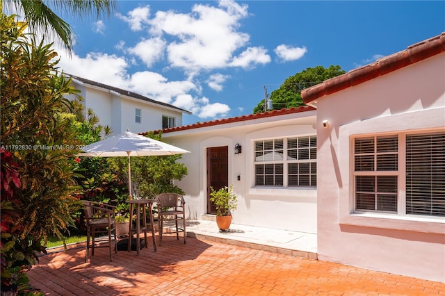 310 Woodcrest Rd, Key Biscayne, FL 33149 - rear view of property with a tile roof, a patio area, stucco siding, and outdoor dining area