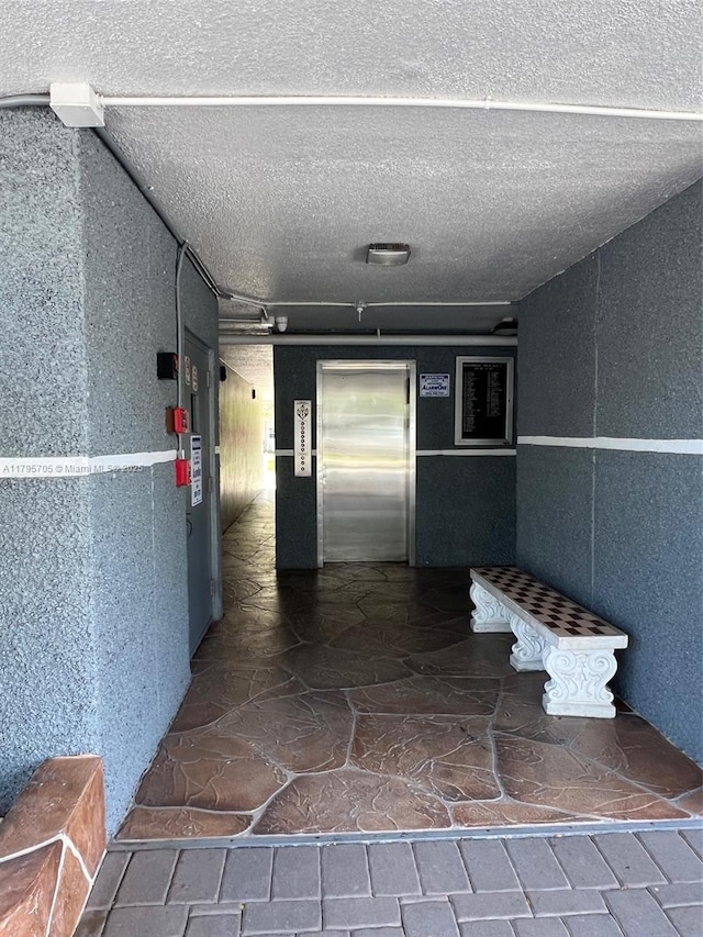619 NE 14th Ave Unit 507, Hallandale Beach, FL 33009 - hall with elevator and stone finish flooring