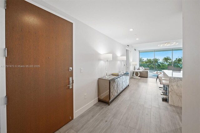 10201 Collins Ave Unit 303, Bal Harbour, FL 33154 - hallway with light wood-style floors, a wall of windows, baseboards, and recessed lighting
