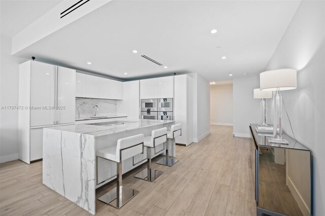 10201 Collins Ave Unit 303, Bal Harbour, FL 33154 - kitchen featuring modern cabinets, a sink, white cabinetry, and recessed lighting