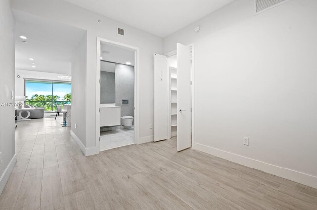 10201 Collins Ave Unit 303, Bal Harbour, FL 33154 - unfurnished bedroom with wood finished floors, baseboards, recessed lighting, ensuite bathroom, and a spacious closet
