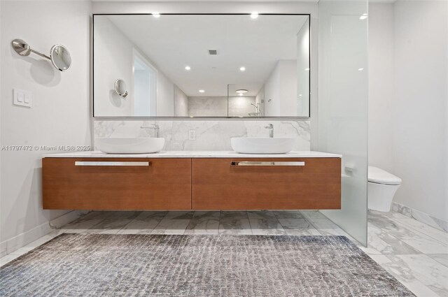 10201 Collins Ave Unit 303, Bal Harbour, FL 33154 - bathroom featuring marble look tile flooring, double vanity, and toilet
