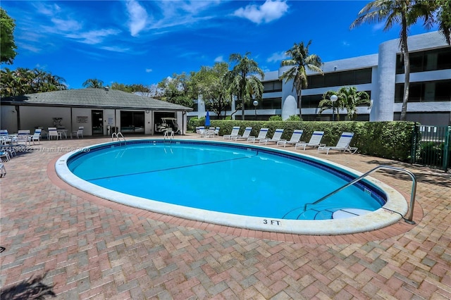 community pool featuring fence and a patio