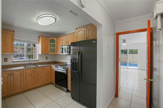kitchen featuring light tile patterned floors, a healthy amount of sunlight, appliances with stainless steel finishes, and a sink