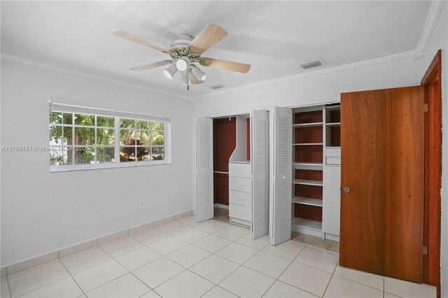 1900 SW 24th St, Miami, FL 33145 - unfurnished bedroom with multiple closets, crown molding, a ceiling fan, and light tile patterned floors