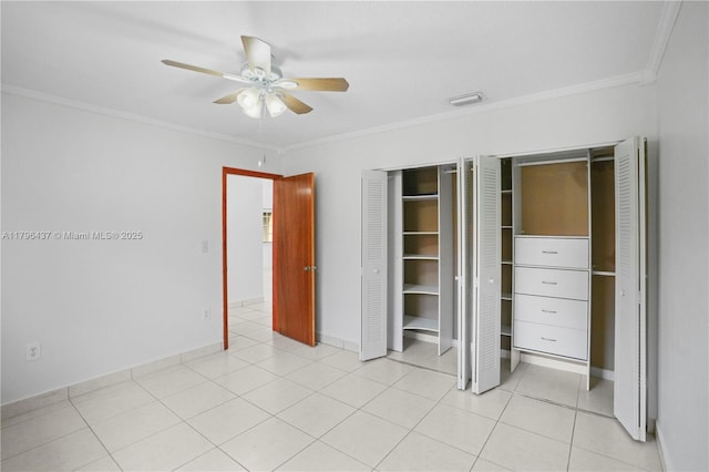 unfurnished bedroom featuring baseboards, ceiling fan, crown molding, and two closets