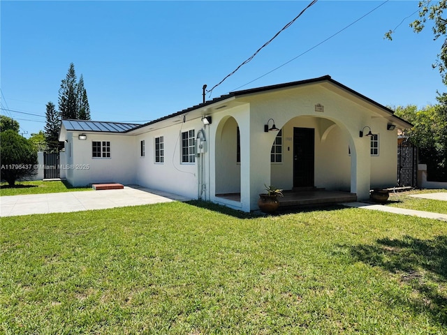 1900 SW 24th St, Miami, FL 33145 - view of front of house featuring stucco siding, a standing seam roof, metal roof, a patio, and covered porch