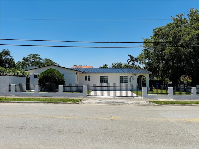 1900 SW 24th St, Miami, FL 33145 - view of front of home featuring stucco siding, a standing seam roof, a metal roof, and a fenced front yard