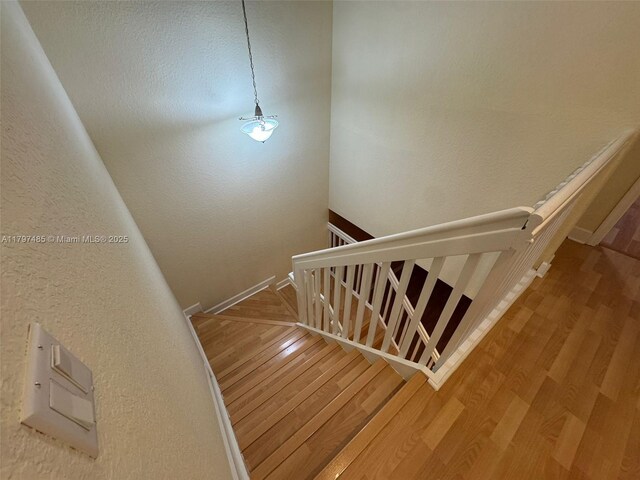 8706 Blaze Ct, Davie, FL 33328 - staircase featuring wood finished floors, a textured wall, and baseboards