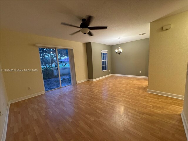 8706 Blaze Ct, Davie, FL 33328 - empty room featuring a chandelier, ceiling fan, light wood finished floors, and baseboards