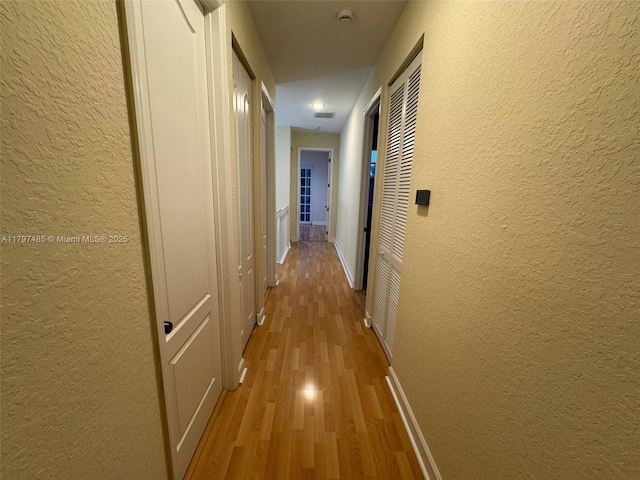 8706 Blaze Ct, Davie, FL 33328 - corridor with a textured wall, light wood-type flooring, and baseboards