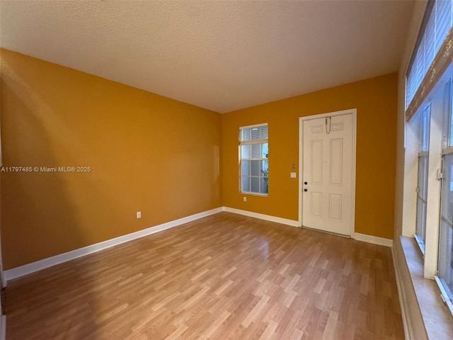 8706 Blaze Ct, Davie, FL 33328 - unfurnished room featuring wood finished floors, baseboards, healthy amount of natural light, and a textured ceiling