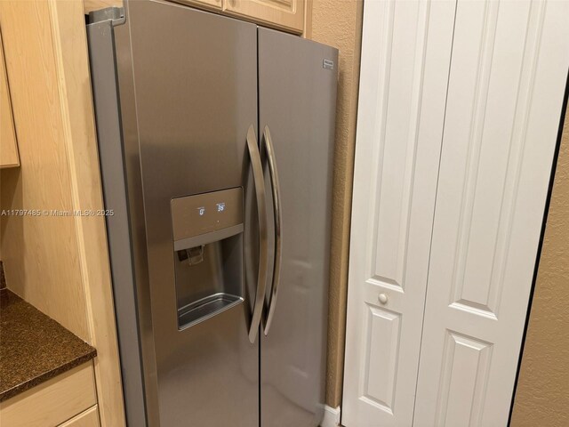 8706 Blaze Ct, Davie, FL 33328 - kitchen with stainless steel refrigerator with ice dispenser, dark stone counters, and a textured wall