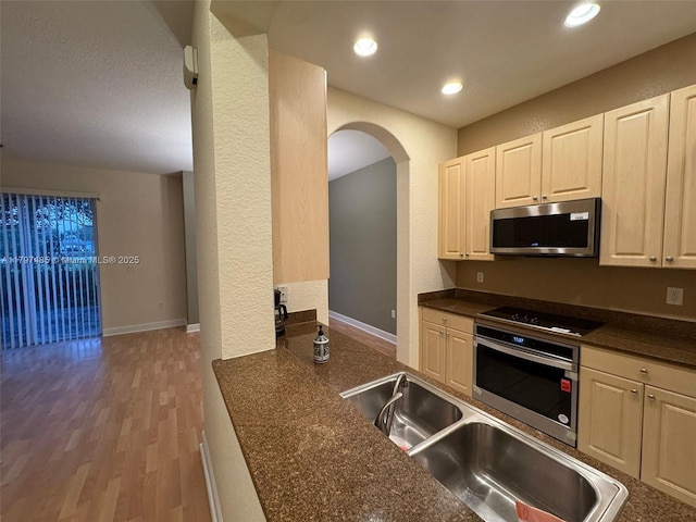 8706 Blaze Ct, Davie, FL 33328 - kitchen with stainless steel appliances, dark countertops, arched walkways, a sink, and recessed lighting