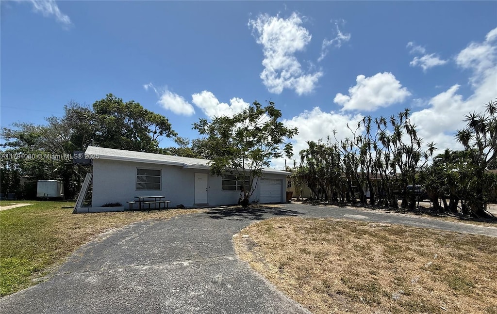 660 SW 14th Pl, Deerfield Beach, FL 33441 - ranch-style home with a front lawn, driveway, stucco siding, and a garage
